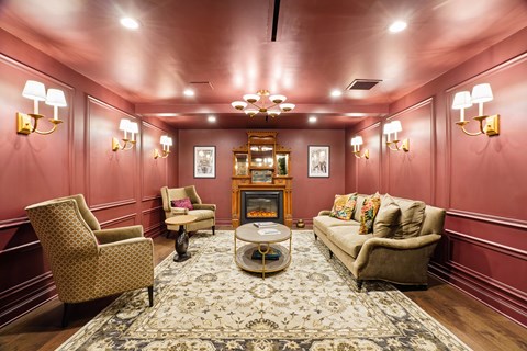 A living room with a sofa, chairs, and a rug.