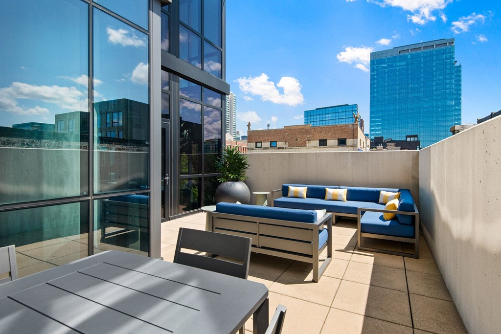 a rooftop patio with a table and chairs