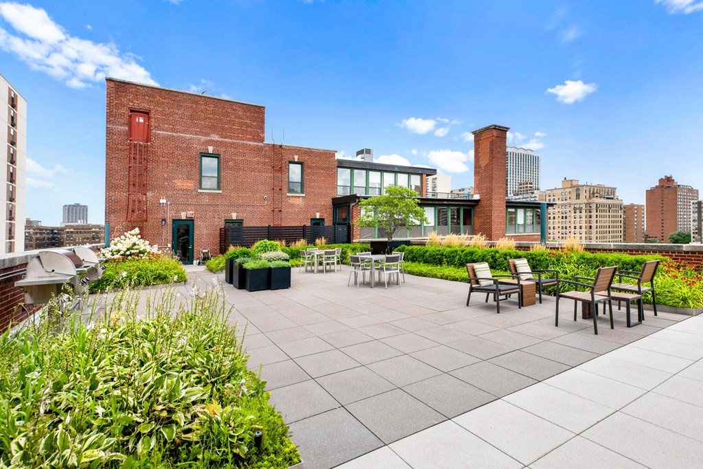 a roof terrace with tables and chairs and a view of the city