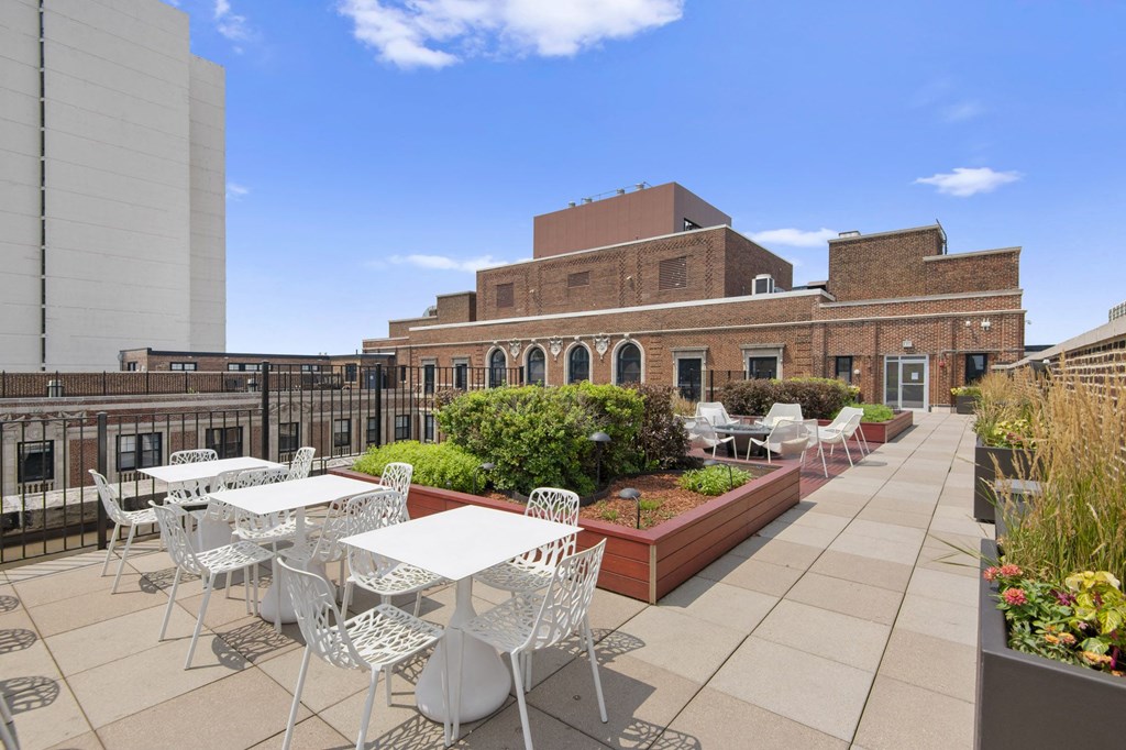 a patio with tables and chairs on the roof of a building