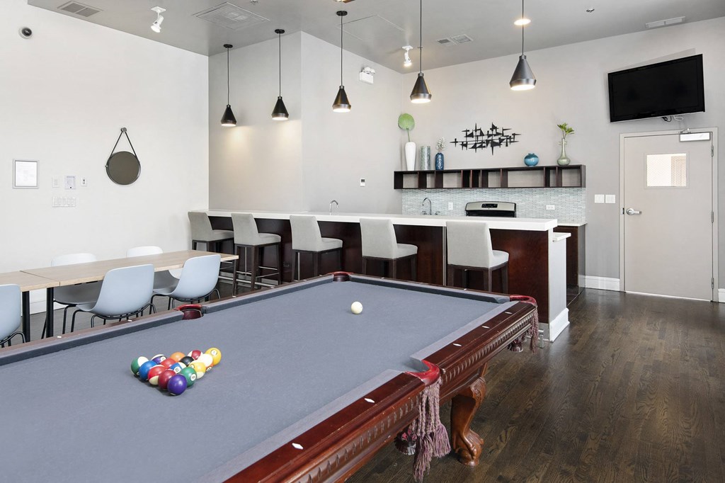 a game room with a pool table and a bar