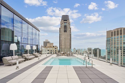 A rooftop pool area with a tall building in the background.