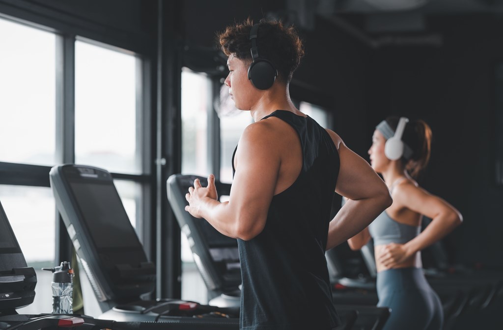 A man and a woman are working out in a gym.