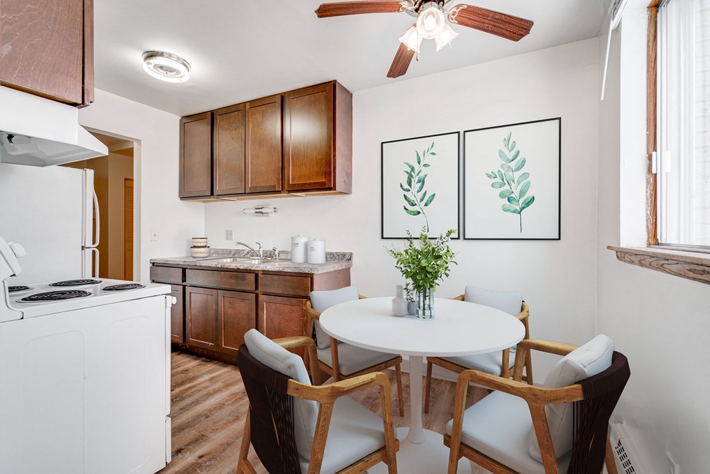 A kitchen with a white table and chairs and a plant on it.