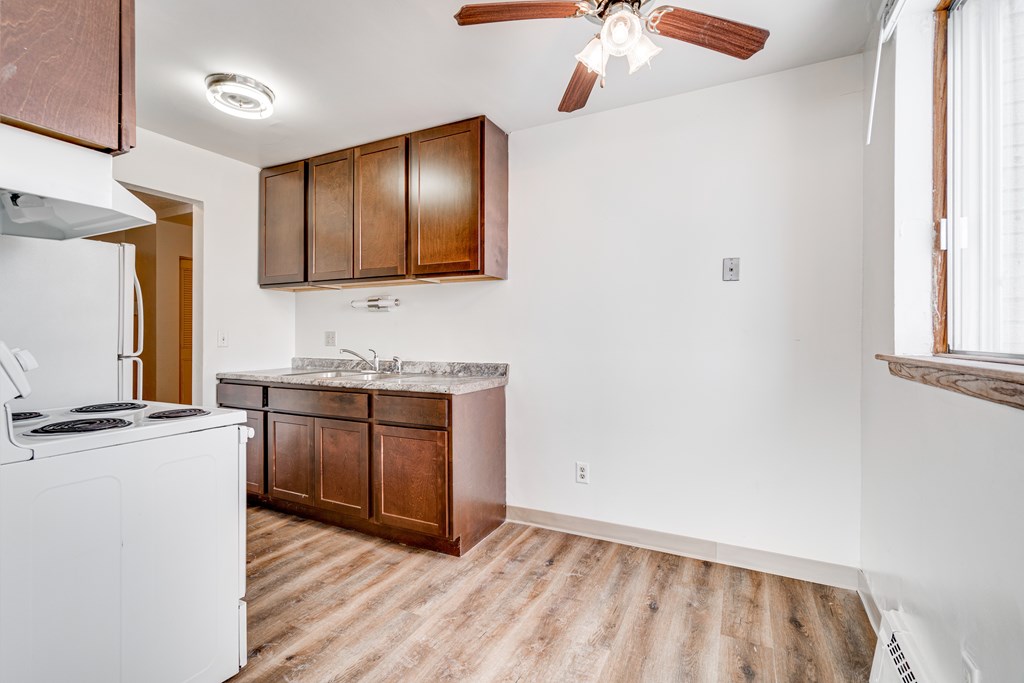 A kitchen with a white fridge and wooden cabinets.