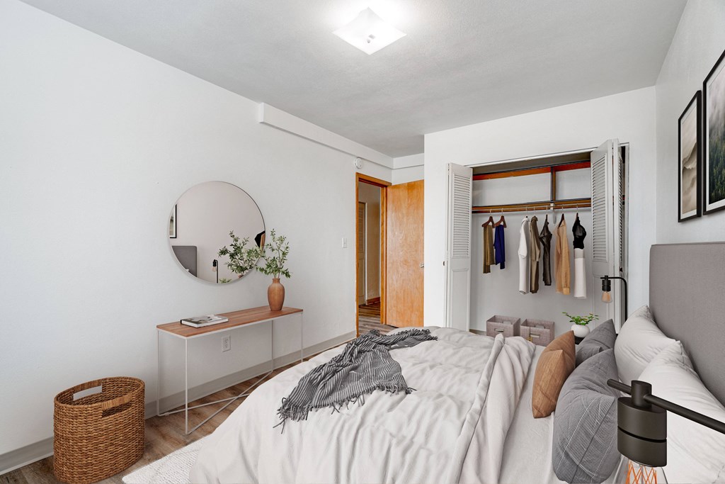 A bedroom with a bed, a mirror, a dresser, and a basket.