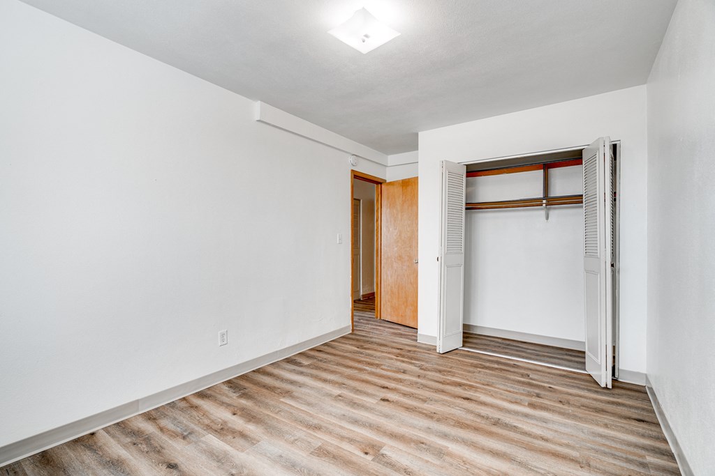 A room with a white wall and a wooden floor.