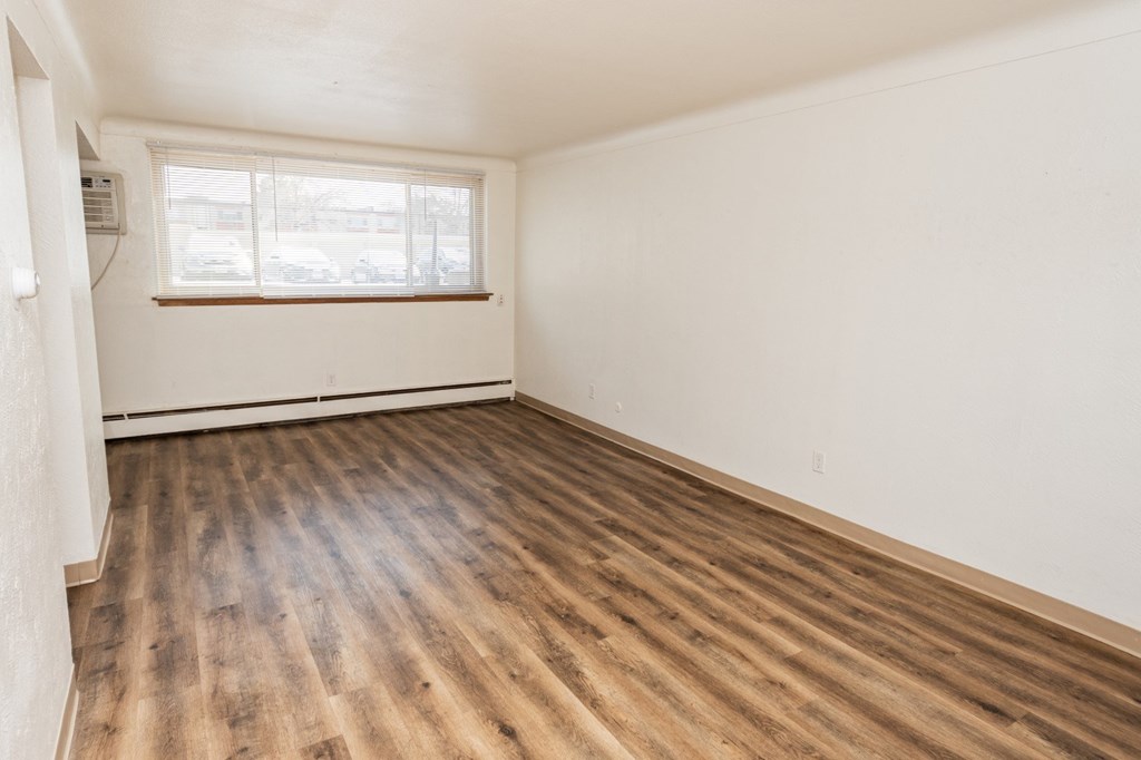 A room with wooden flooring and a window.