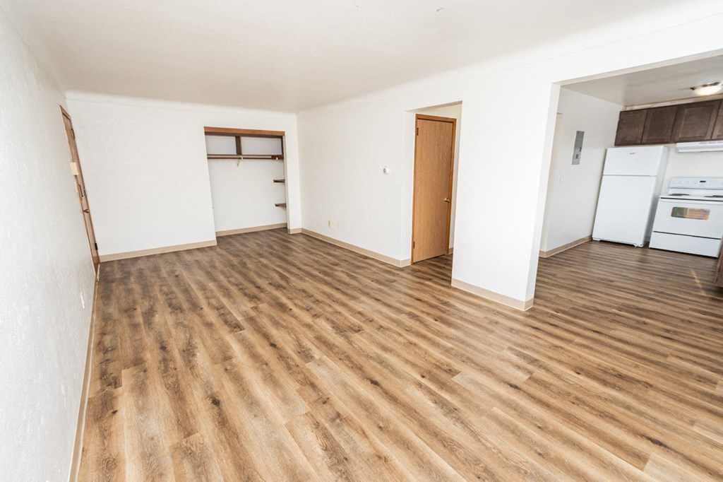 A room with wooden flooring and white walls.
