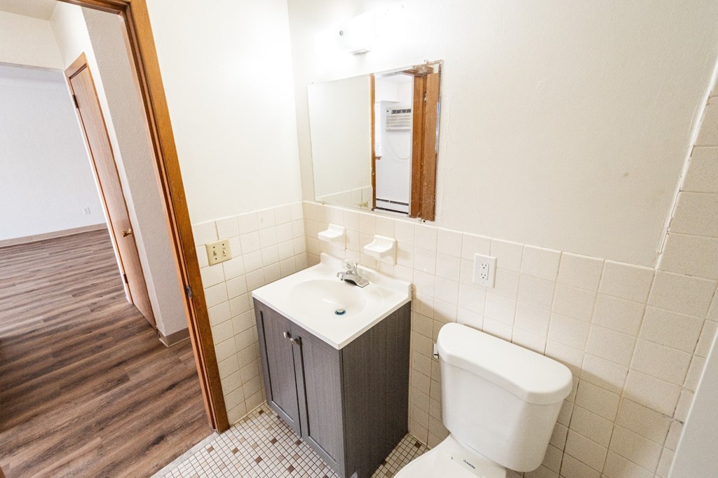 A white toilet sits next to a sink in a small bathroom.