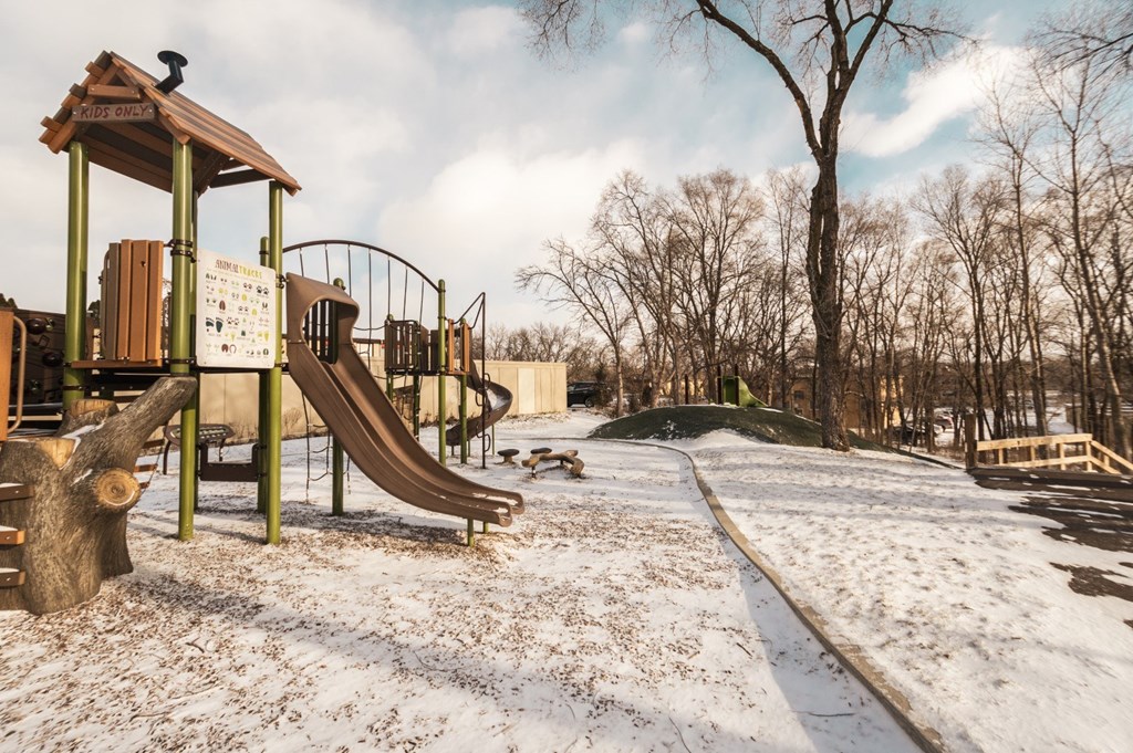 A playground with a slide and a wooden structure.
