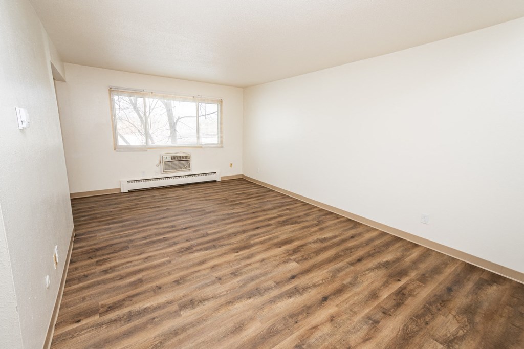 A room with wooden flooring and a window.