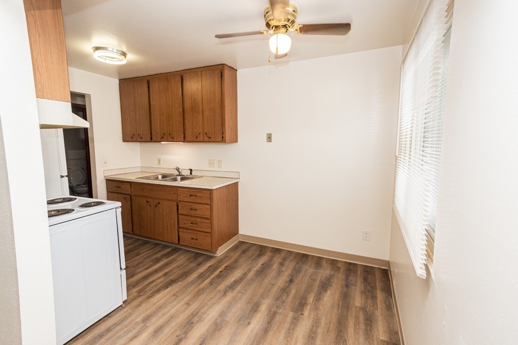 A kitchen with wooden floors and white appliances.