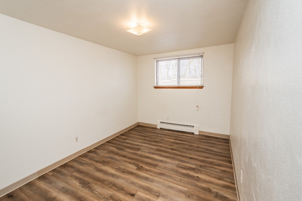 A room with wooden flooring and a window.