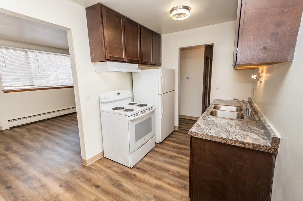 A kitchen with a white stove and a sink.