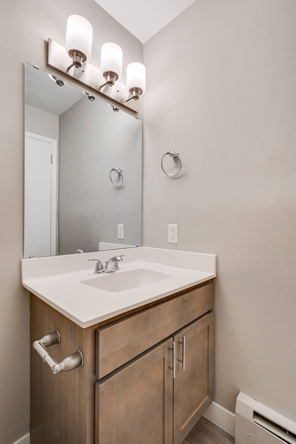A bathroom with a sink and a mirror above it.
