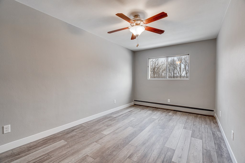 A room with a ceiling fan and a window.