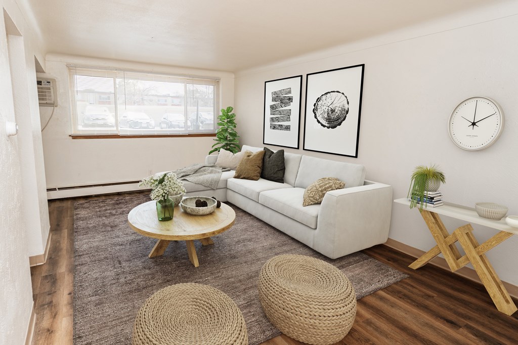 A living room with a white couch, a wooden coffee table, and a woven ottoman.