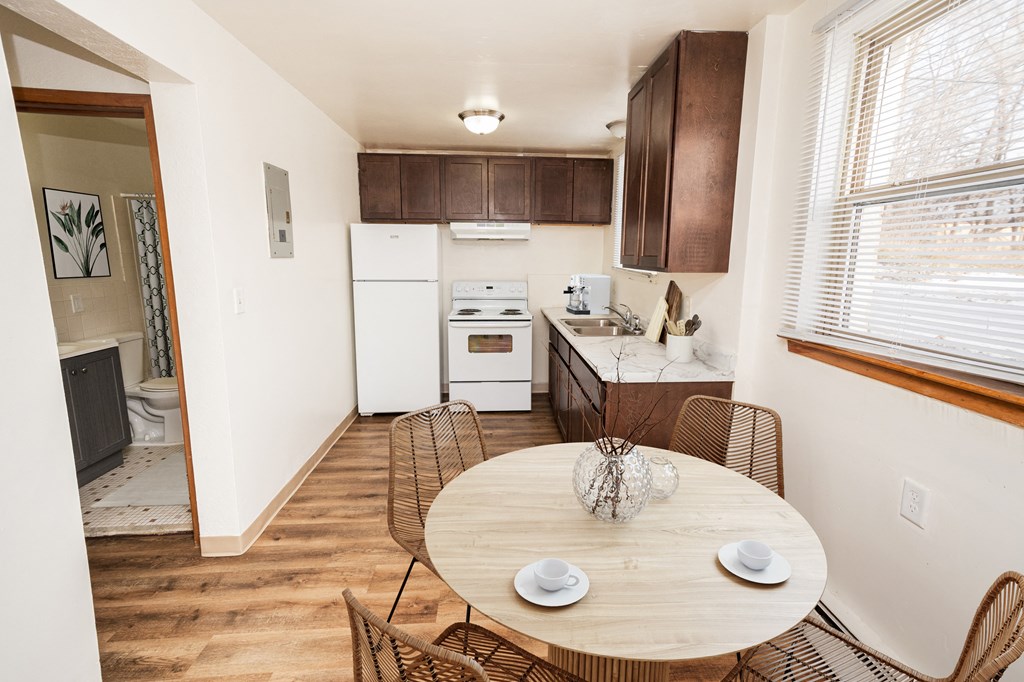 A kitchen with a table and chairs in the middle of the room.