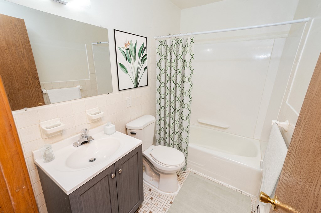 A bathroom with a toilet, sink, and shower.