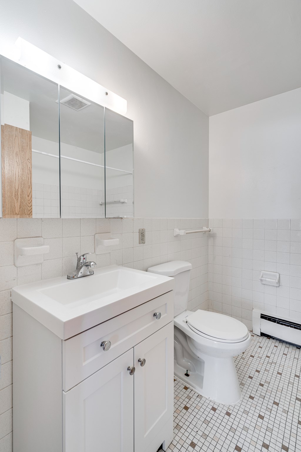 A white bathroom with a sink, toilet and mirror.