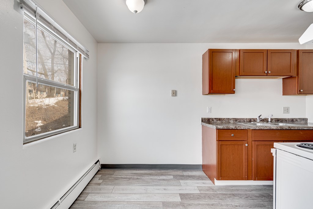 A kitchen with white appliances and wooden cabinets.