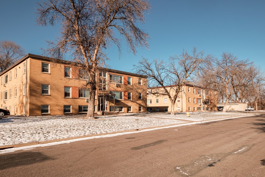 Apartment building with a tree in front of it.
