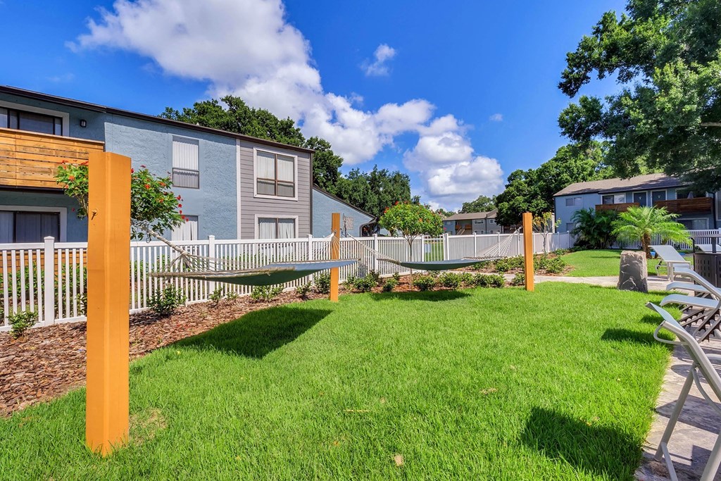 A sunny day at a residential area with a green lawn and apartment buildings.