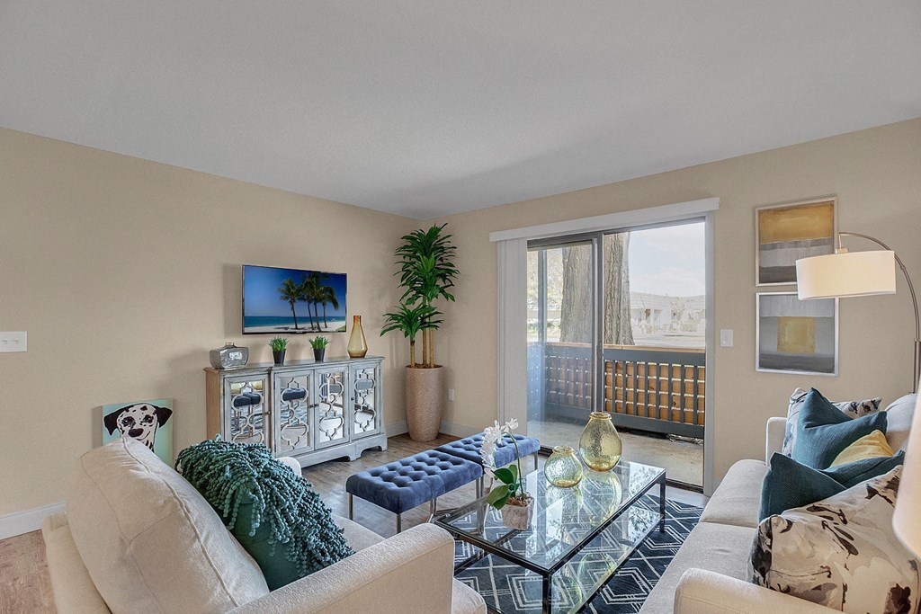 A living room with a glass coffee table and a couch.