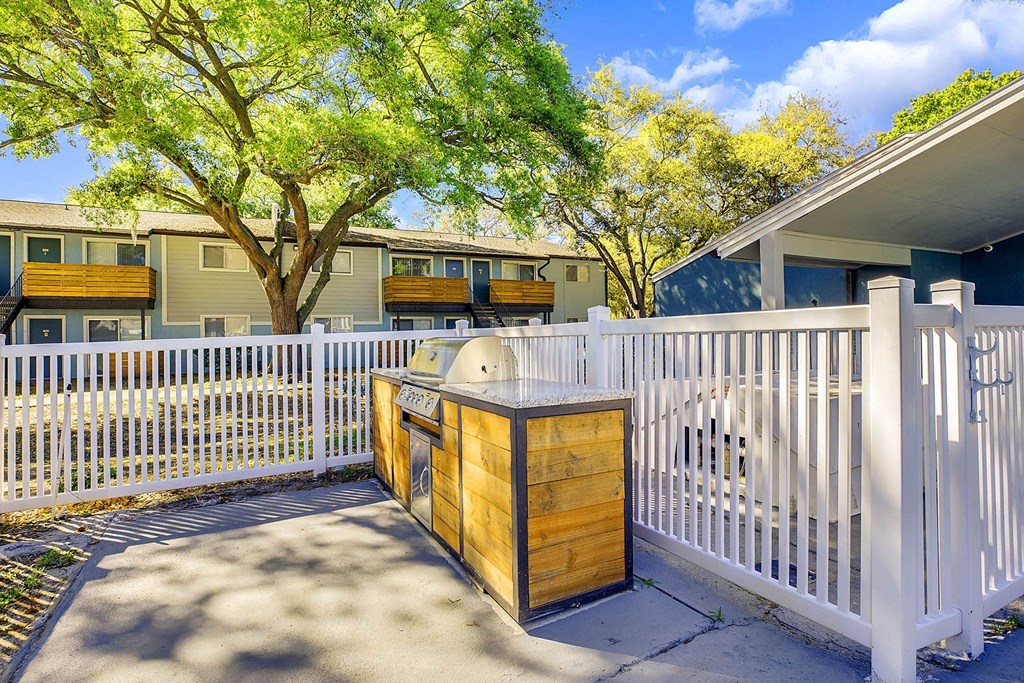 A white picket fence surrounds a wooden mailbox.