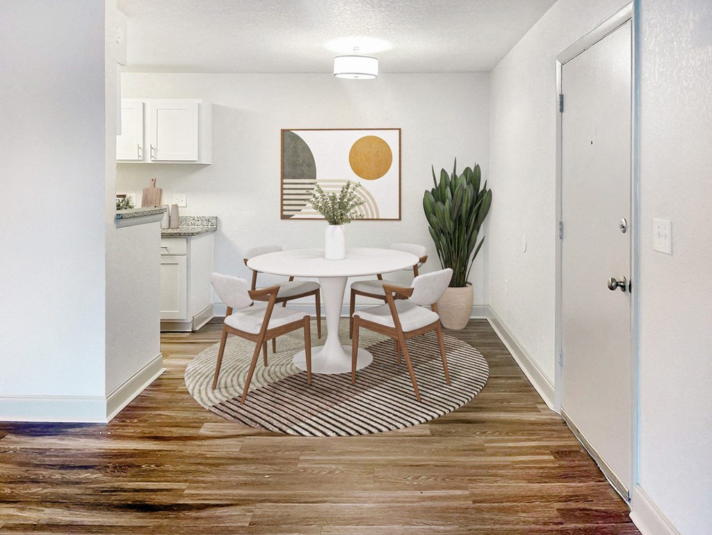 A dining room with a white table and chairs.