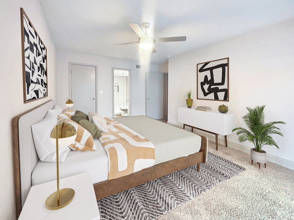 A bedroom with a bed, a lamp, and a ceiling fan.