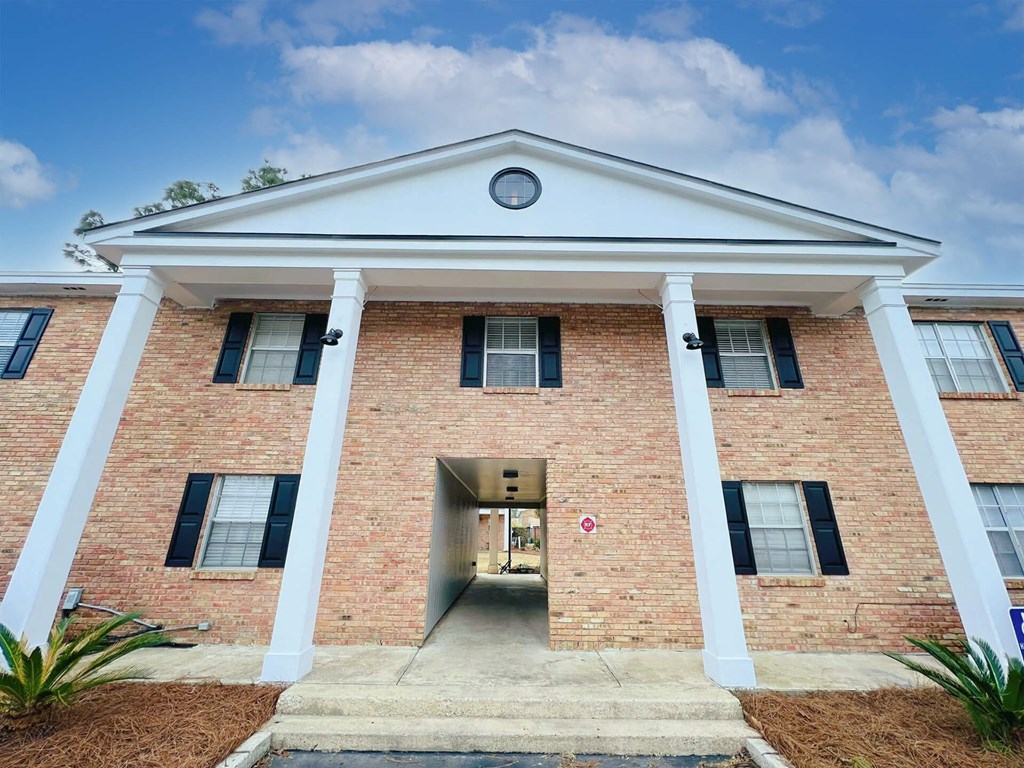A red brick building with a white roof and columns.