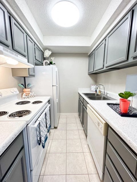 A kitchen with a white stove top oven and a white refrigerator.