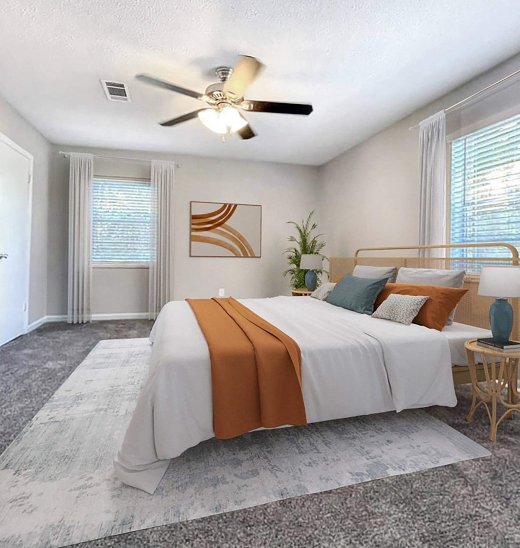 A bedroom with a large bed and a ceiling fan.