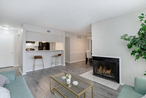 A living room with a fireplace and a glass coffee table.