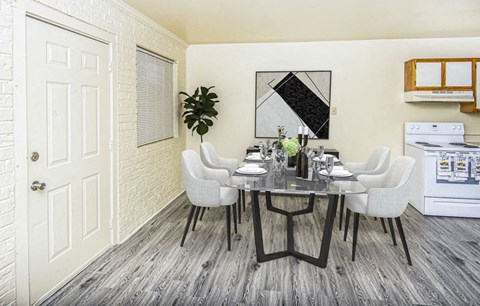 A dining room with a white table and chairs.