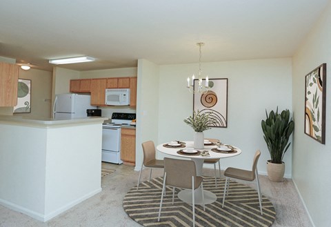 A kitchen with a dining table and chairs.