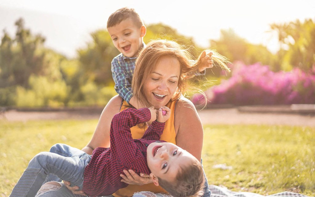 A woman and two children are having fun outdoors.