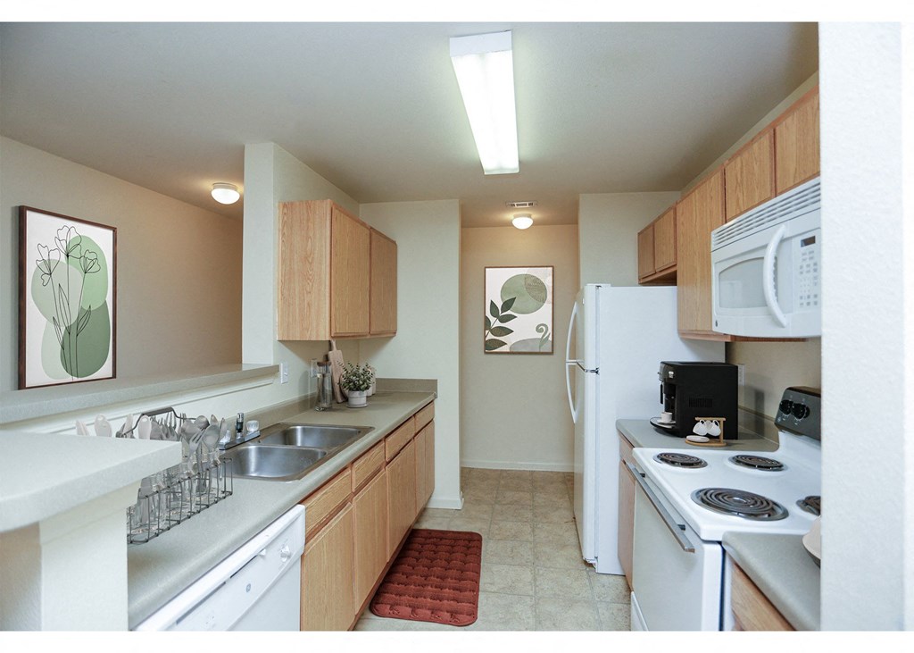 A kitchen with white appliances and wooden cabinets.