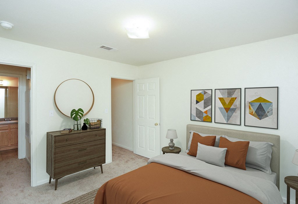 A bedroom with a bed, nightstand, and a plant on a dresser.