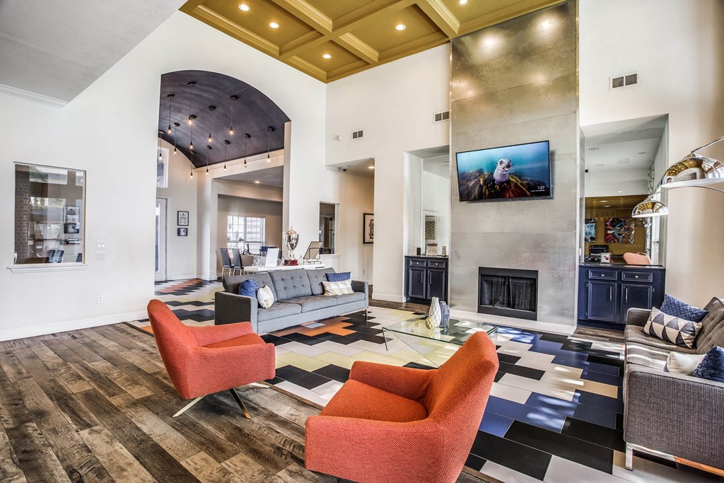 A living room with a grey couch and a fireplace.