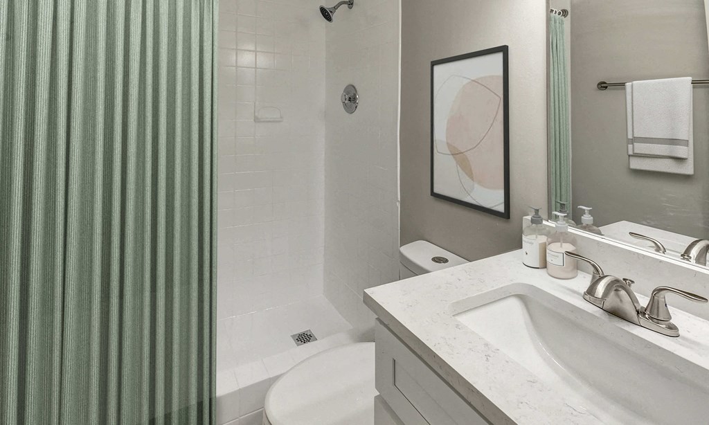 A bathroom with a green striped shower curtain.