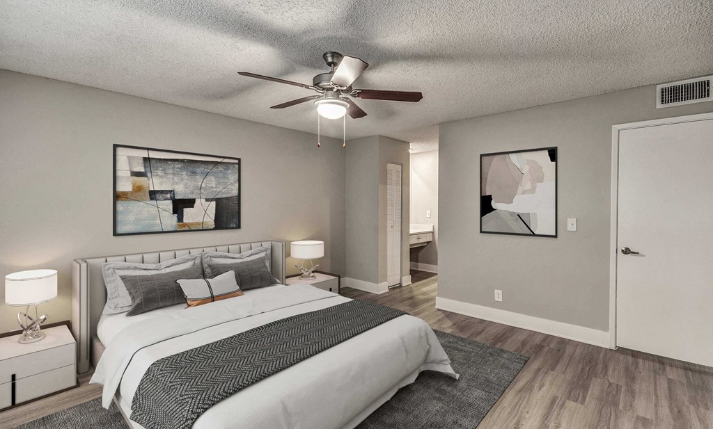 A bedroom with a large bed and a ceiling fan.