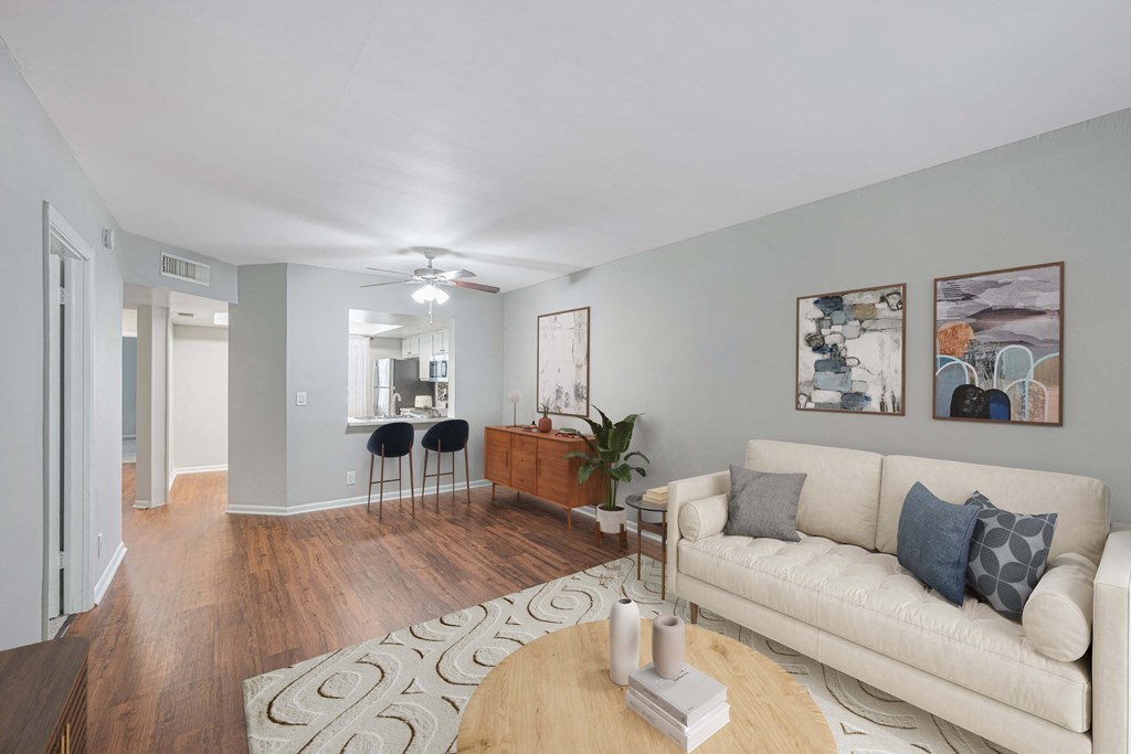 A living room with a white couch and a wooden coffee table.