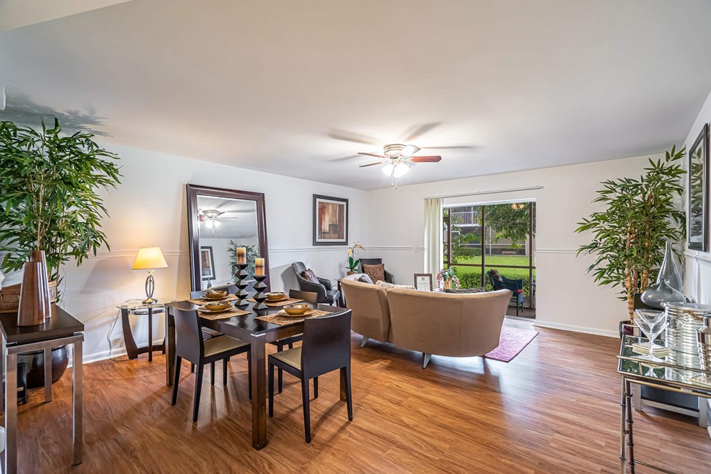 A dining room with a table set for six and a ceiling fan.