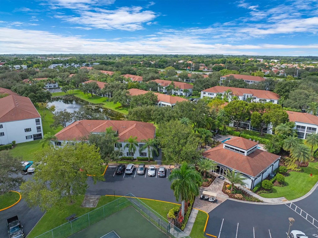 A bird's eye view of a residential area with houses, a parking lot, and a basketball court.