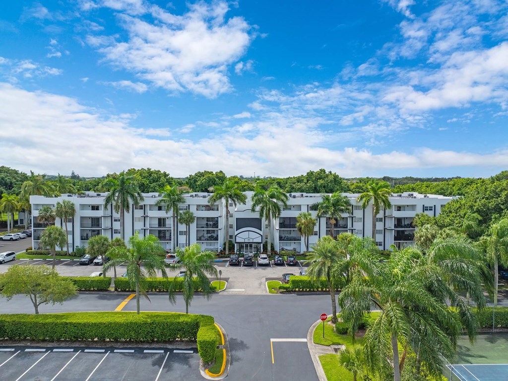 A sunny day at a resort with a tennis court and palm trees.