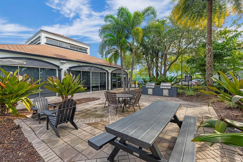 A patio with a table and chairs is surrounded by trees.