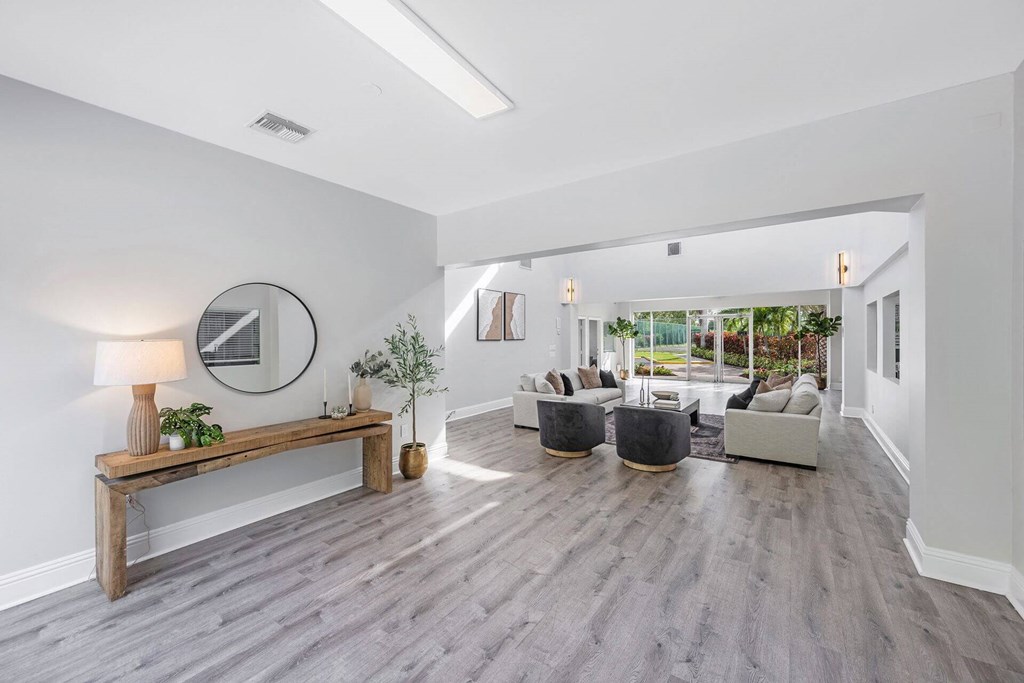 A modern living room with a wooden bench and grey couches.